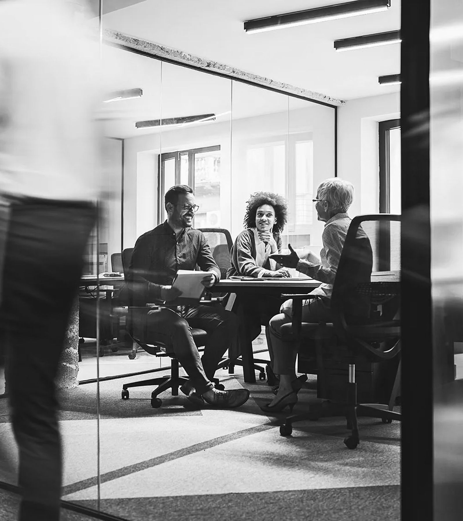Three professionals working through documents together at a table